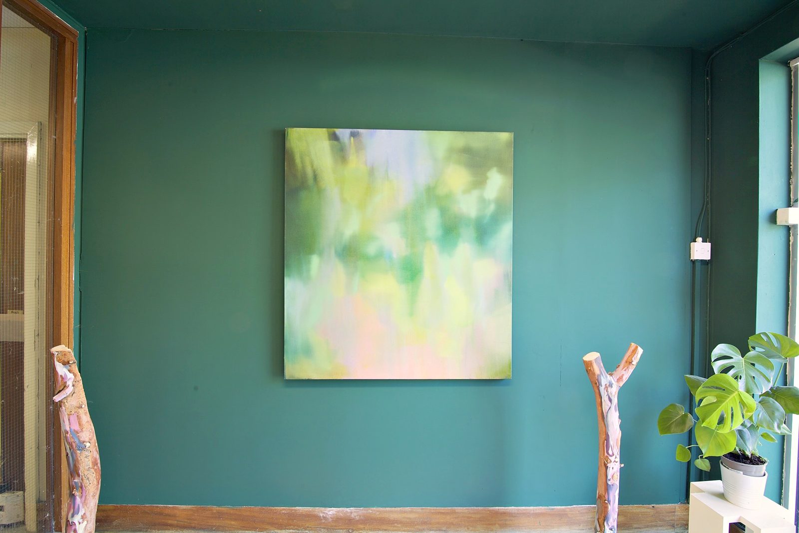 A teal room with a painting