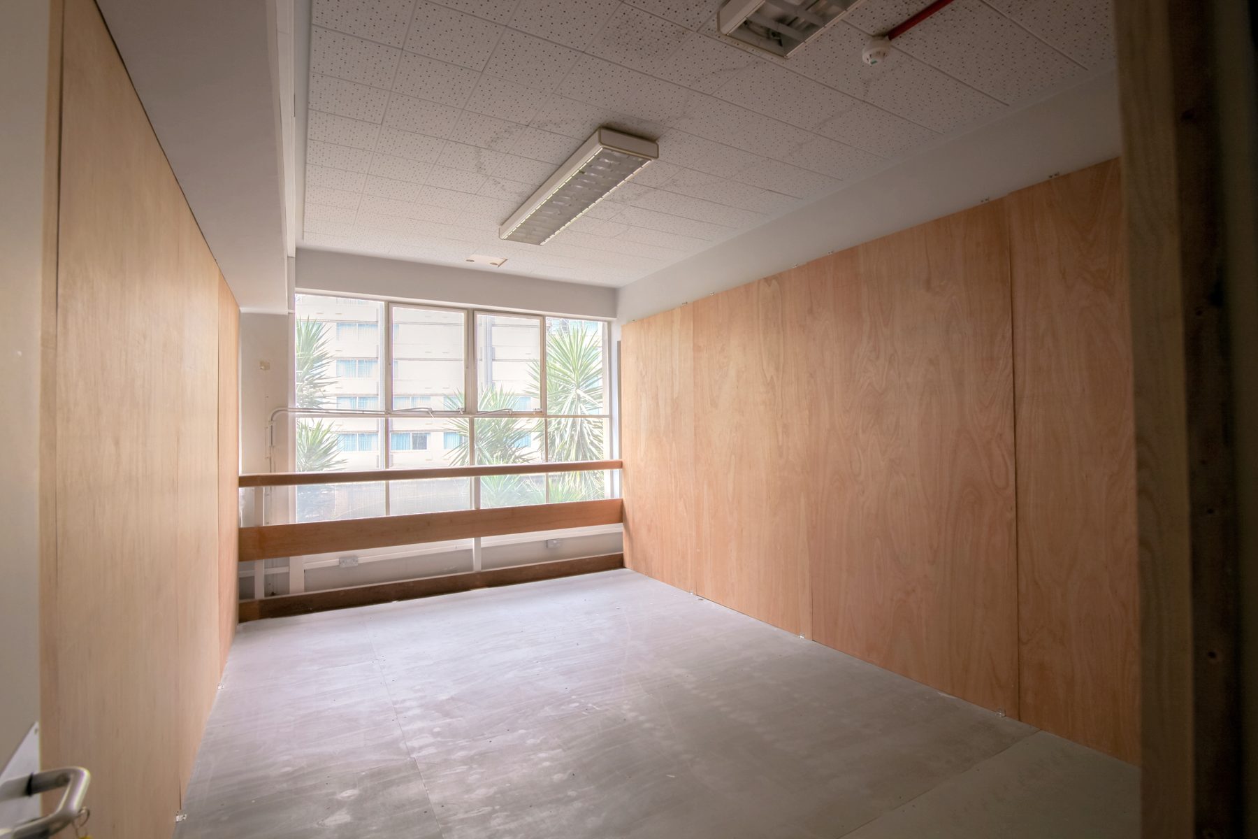 An empty private studio with plywood walls